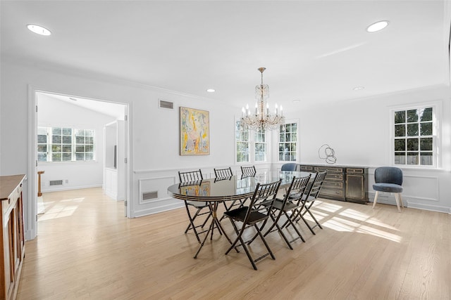 dining area with light wood-type flooring, visible vents, a chandelier, and crown molding