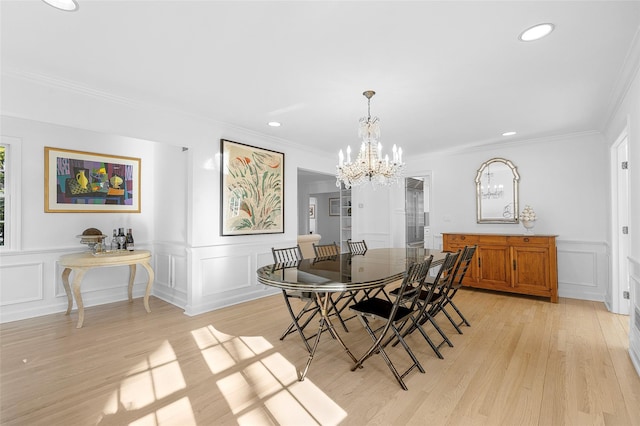 dining area with recessed lighting, a decorative wall, an inviting chandelier, ornamental molding, and light wood-type flooring