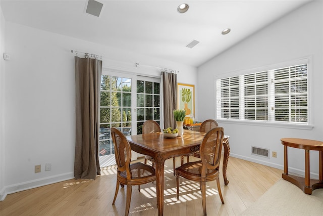 dining room with light wood-style floors, lofted ceiling, visible vents, and plenty of natural light