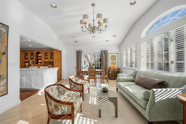 living room featuring light wood-style flooring, a notable chandelier, recessed lighting, baseboards, and vaulted ceiling