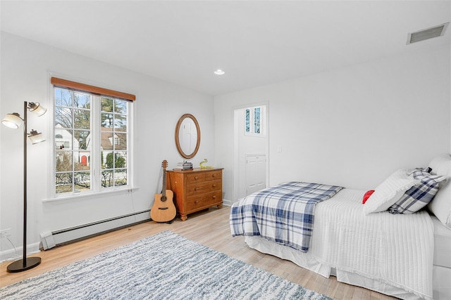 bedroom featuring recessed lighting, wood finished floors, visible vents, baseboards, and baseboard heating