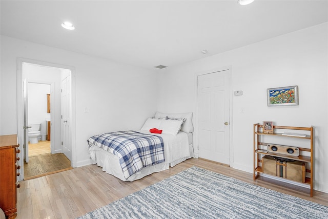 bedroom with recessed lighting, visible vents, ensuite bathroom, wood finished floors, and baseboards