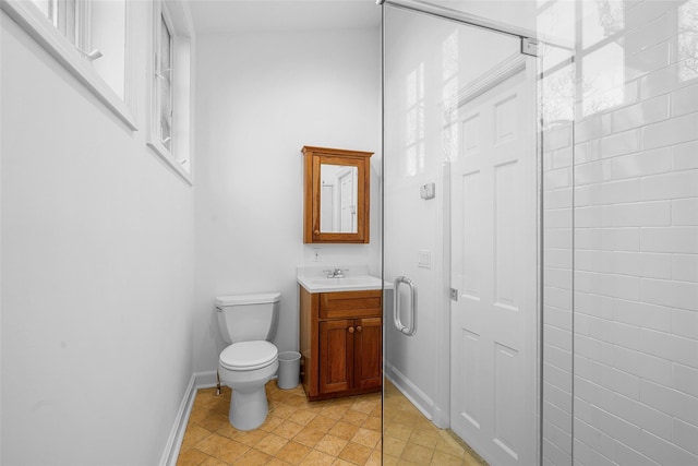 bathroom featuring vanity, toilet, and baseboards