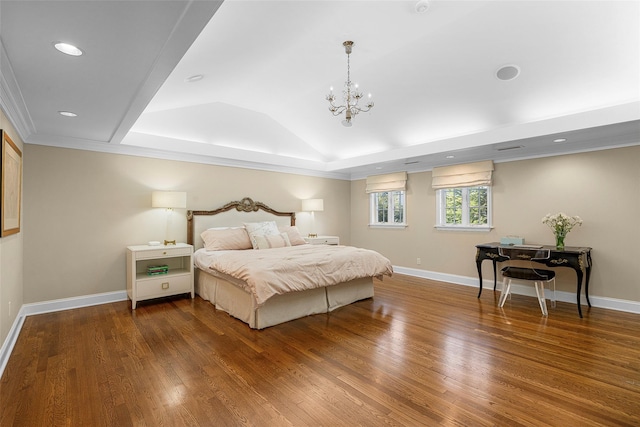 bedroom with vaulted ceiling, a raised ceiling, wood finished floors, and baseboards