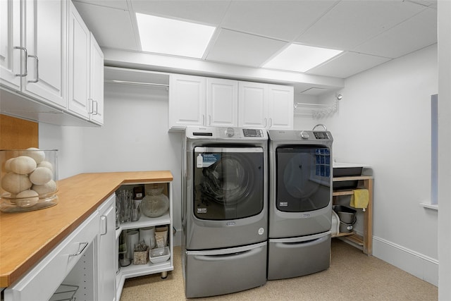 laundry room with cabinet space, washer and clothes dryer, and baseboards