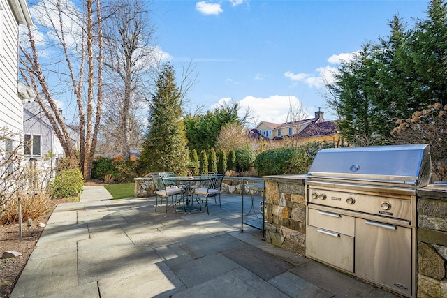 view of patio / terrace featuring outdoor dining space, an outdoor kitchen, and fence