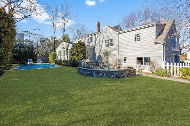 rear view of property with a patio, a chimney, and fence