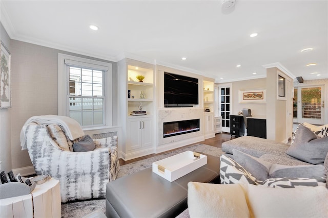 living room featuring crown molding, built in features, and wood-type flooring