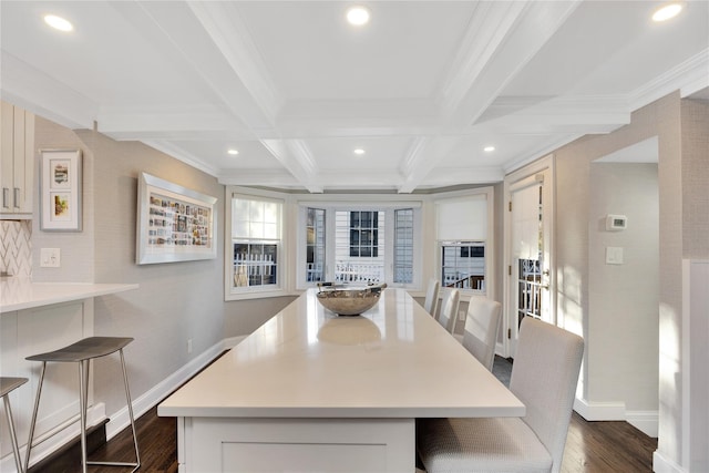 dining area featuring dark wood-type flooring, ornamental molding, beam ceiling, and coffered ceiling