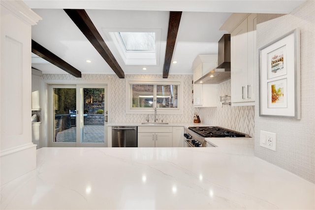 kitchen with dishwasher, wall chimney range hood, sink, beamed ceiling, and range