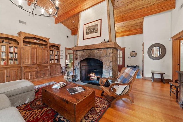 living room with beamed ceiling, light hardwood / wood-style flooring, wooden ceiling, and a fireplace