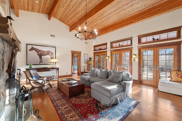 living room featuring wooden ceiling, beamed ceiling, french doors, high vaulted ceiling, and a notable chandelier