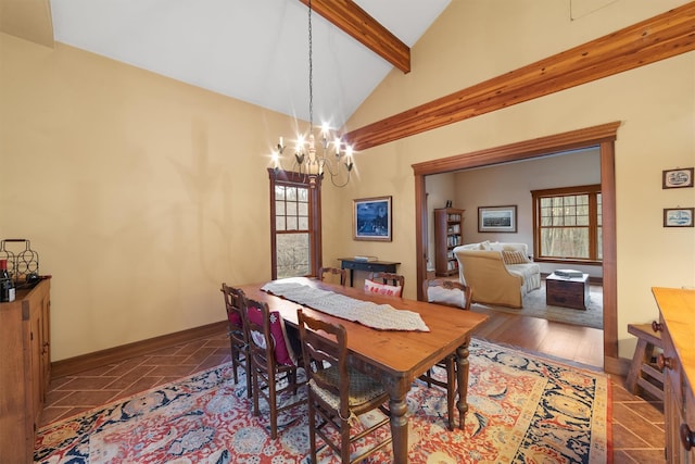 dining area with high vaulted ceiling, a chandelier, a healthy amount of sunlight, and beam ceiling