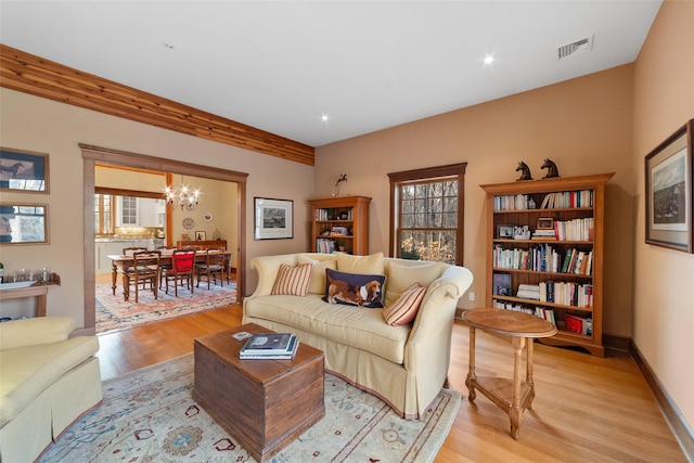 living room with light hardwood / wood-style flooring, a wealth of natural light, and a chandelier