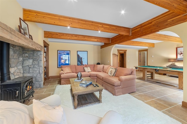 living room with pool table, a wood stove, and beam ceiling