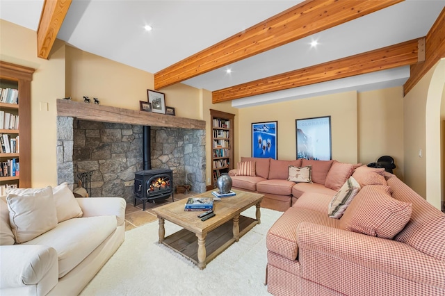 living room featuring a wood stove and beam ceiling