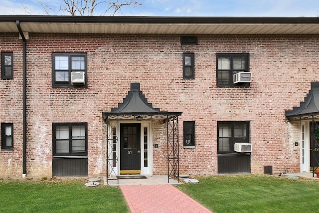 view of front facade with a front yard and cooling unit