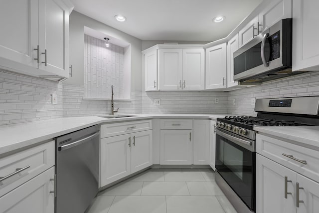 kitchen featuring appliances with stainless steel finishes, white cabinetry, sink, and light tile patterned floors