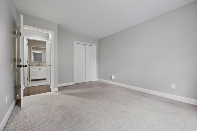 unfurnished bedroom with sink, a closet, and light carpet