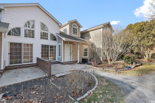 view of front of property featuring central AC unit and a patio