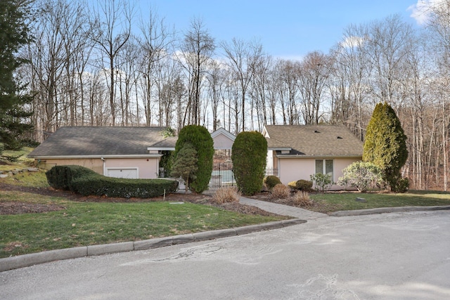 single story home featuring a front lawn and a garage