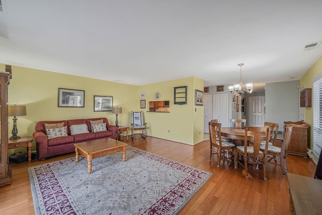 living room with light hardwood / wood-style flooring and an inviting chandelier