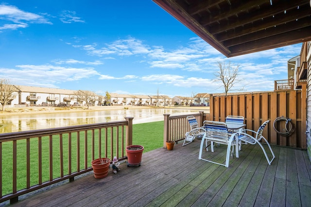 deck with a water view and a lawn