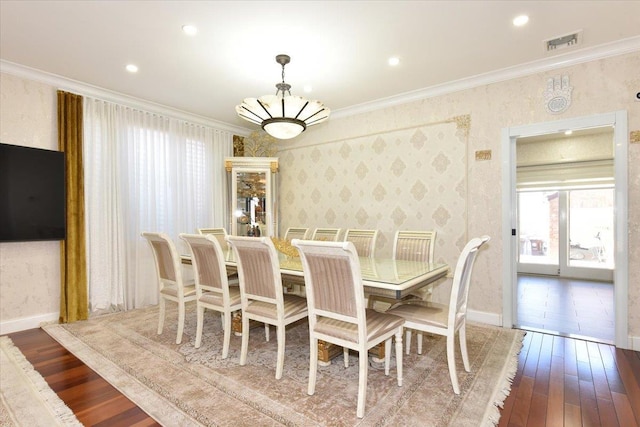 dining space with ornamental molding, dark wood-type flooring, and a notable chandelier