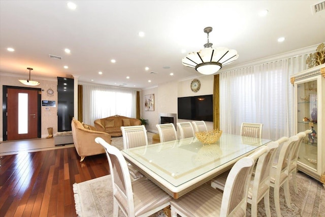 dining area with dark hardwood / wood-style flooring and crown molding