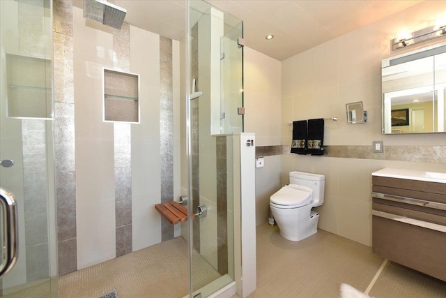 bathroom featuring vanity, toilet, an enclosed shower, and tile walls