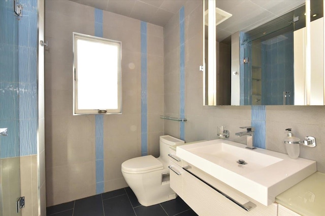 bathroom featuring decorative backsplash, vanity, tile patterned flooring, and tile walls