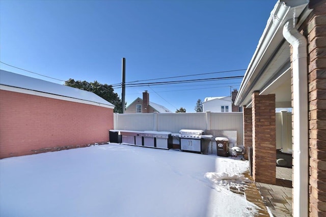 snow covered patio featuring grilling area