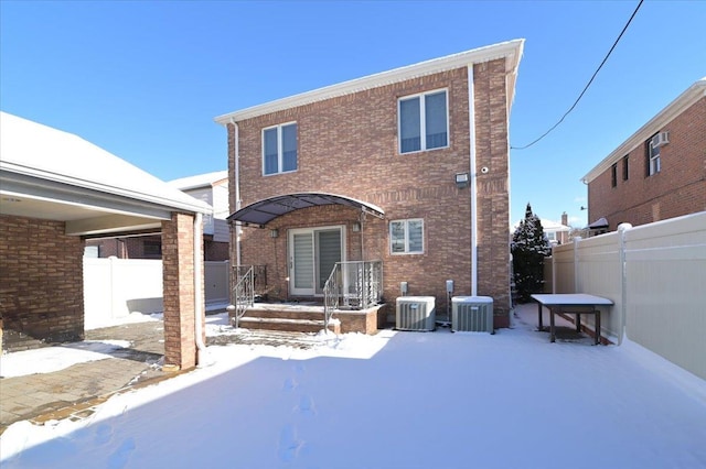 snow covered back of property with central AC unit