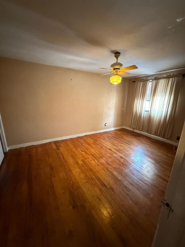 spare room with ceiling fan and hardwood / wood-style flooring