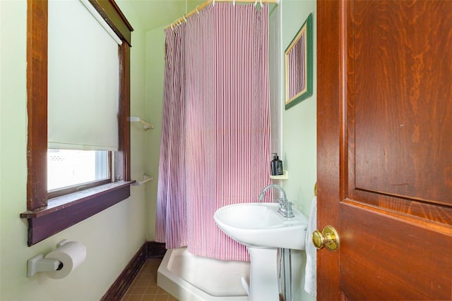 bathroom featuring lofted ceiling, a shower, and tile patterned floors