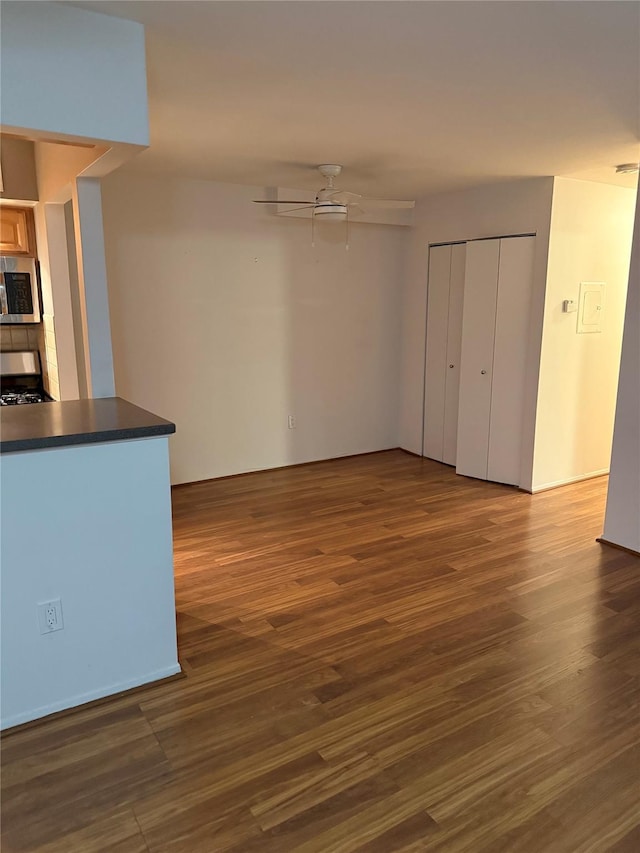 interior space featuring ceiling fan, stove, and dark hardwood / wood-style floors