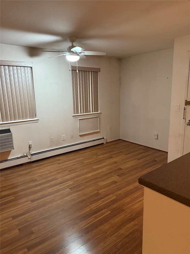 empty room featuring dark hardwood / wood-style floors, ceiling fan, an AC wall unit, and a baseboard heating unit