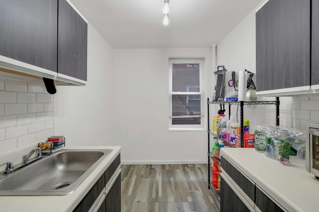 kitchen featuring decorative backsplash, sink, and light hardwood / wood-style flooring