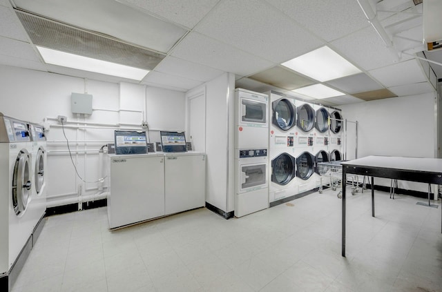 clothes washing area with stacked washing maching and dryer and washing machine and clothes dryer