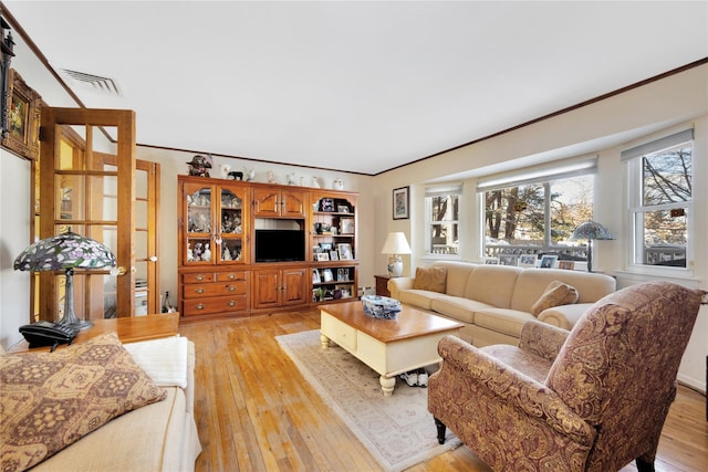 living room featuring light hardwood / wood-style flooring and crown molding