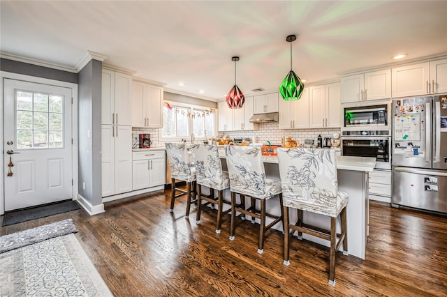 kitchen featuring stainless steel appliances, white cabinetry, a wealth of natural light, and hanging light fixtures