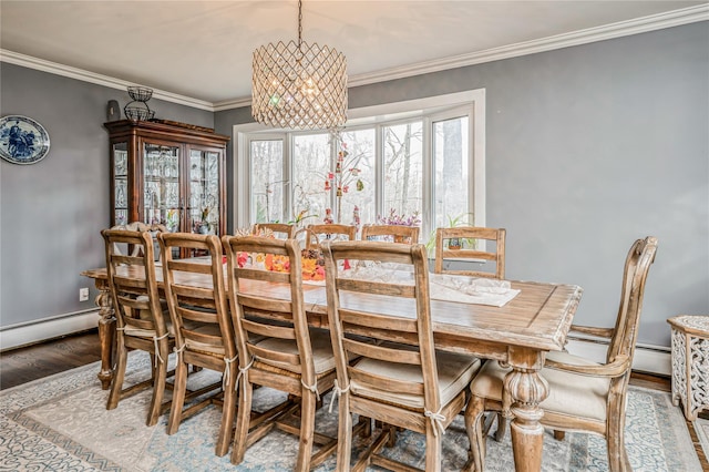 dining space featuring hardwood / wood-style flooring, an inviting chandelier, crown molding, and baseboard heating