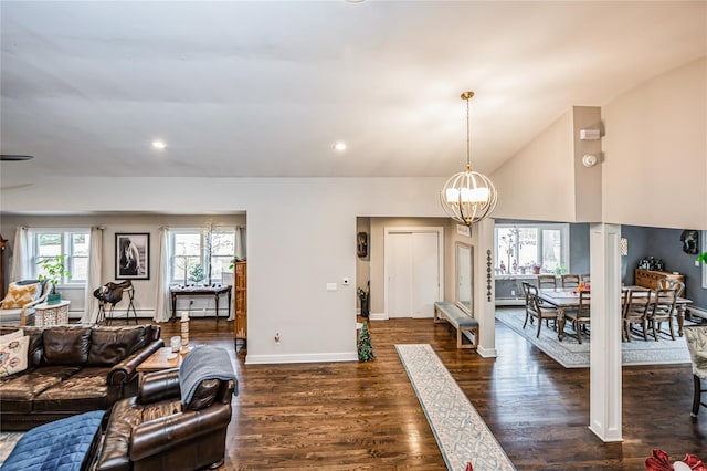 living room featuring vaulted ceiling, a notable chandelier, and dark hardwood / wood-style floors