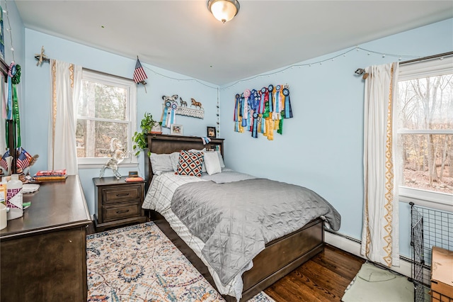 bedroom featuring baseboard heating and dark hardwood / wood-style flooring