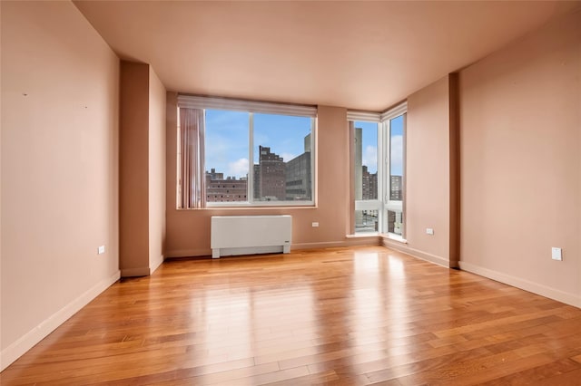 empty room featuring light hardwood / wood-style floors and radiator heating unit