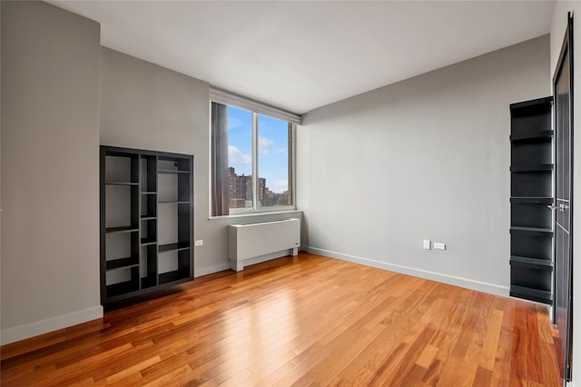 spare room with radiator and wood-type flooring