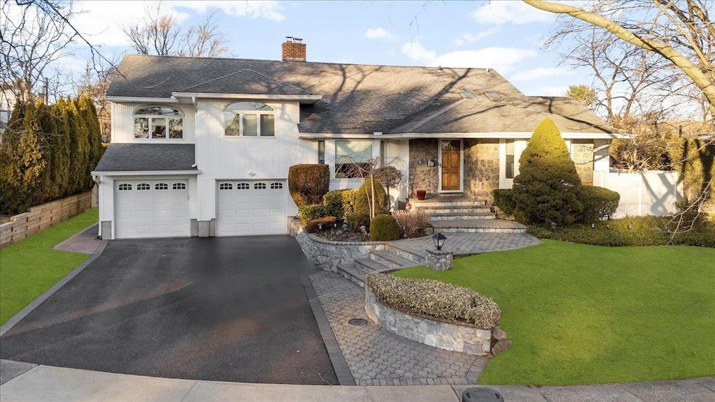 view of front of house featuring a garage and a front lawn