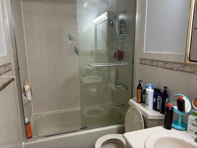 full bathroom with vanity, toilet, shower / bath combination with glass door, and tile walls