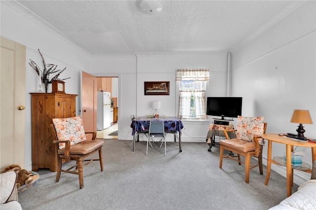 living room featuring carpet, a textured ceiling, and ornamental molding