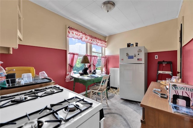 kitchen with radiator heating unit, carpet floors, and white appliances